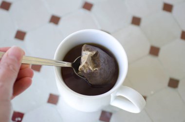 Bir çay poşeti ve kaşık çay