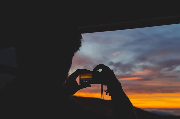 Güneşin doğuşunu pencereden fotoğrafını bir adam silüeti