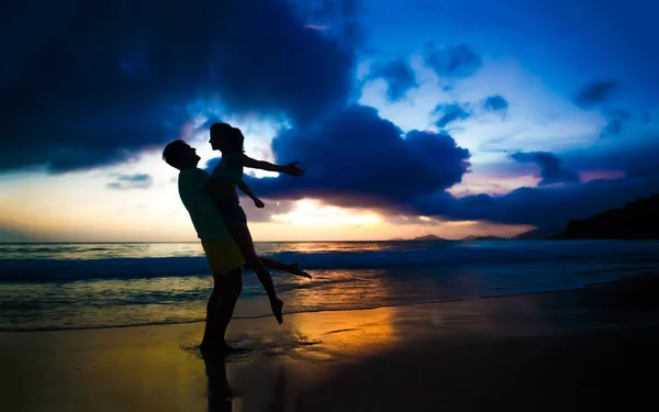 Junges verliebtes Paar umarmt sich am Strand bei Sonnenuntergang — Stockfoto