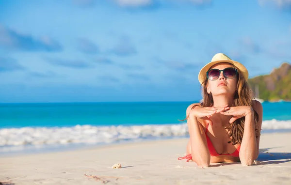 Tropik sahilde yalan bikini ve saman şapkalı kadın — Stok fotoğraf