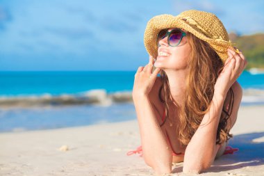 tropik sahilde yalan bikini ve saman şapkalı kadın