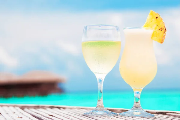 Glass of fruit cocktail and sunglasses by the beach — Stock Photo, Image