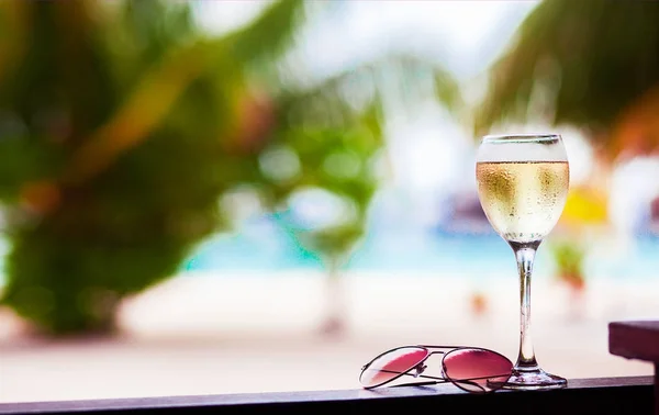 Glas gekoeld witte wijn op tafel in de buurt van het strand — Stockfoto