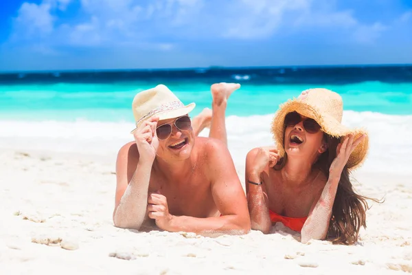 Gelukkige jonge paar liegen en plezier op een tropisch strand — Stockfoto