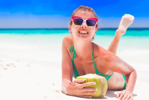 Woman in bikini with coconut cocktail relaxing at white sand beach — Stock Photo, Image