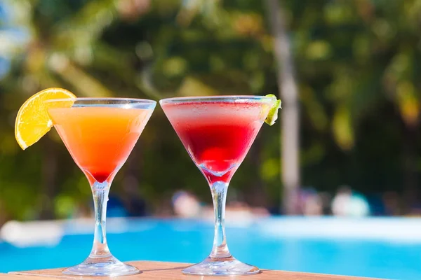 Glass of fruit cocktail and sunglasses by the beach — Stock Photo, Image