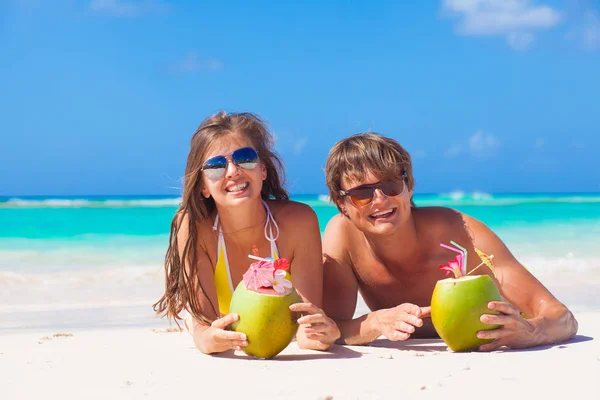 Pareja acostada en una playa tropical en Barbados y bebiendo un cóctel de coco —  Fotos de Stock