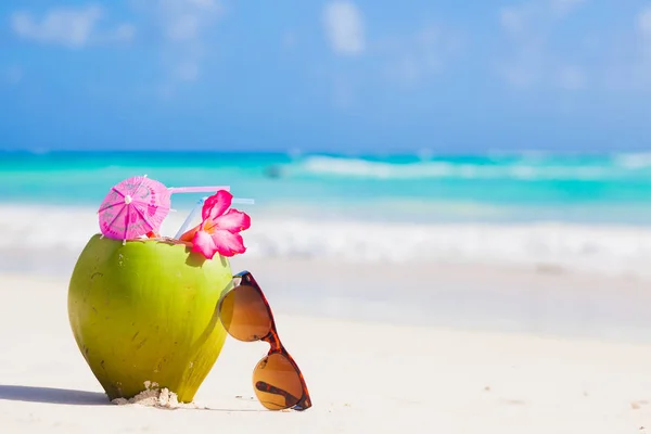Foto de suco de coco fresco e óculos de sol na praia tropical — Fotografia de Stock