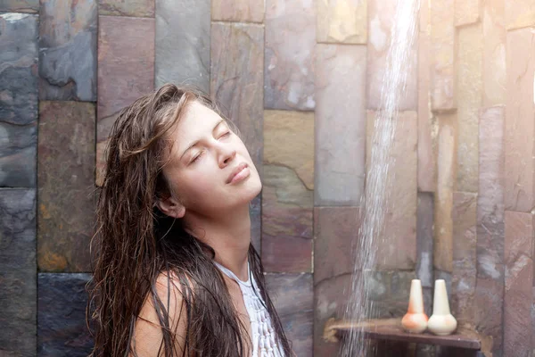 Jonge vrouw verfrissend in douche in de buurt van zwembad — Stockfoto