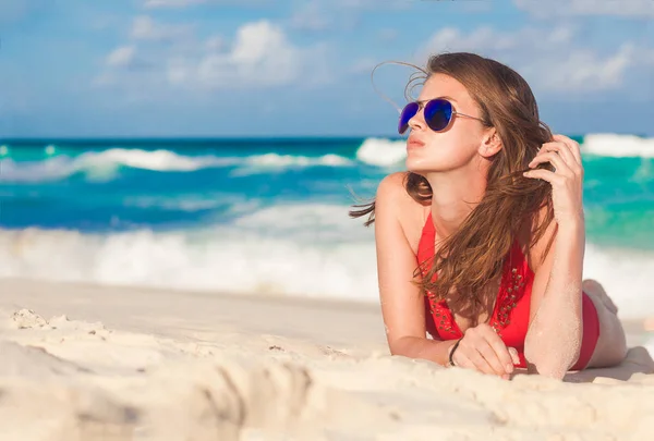 Woman in bikini and straw hat lying on tropical beach — Stock Photo, Image