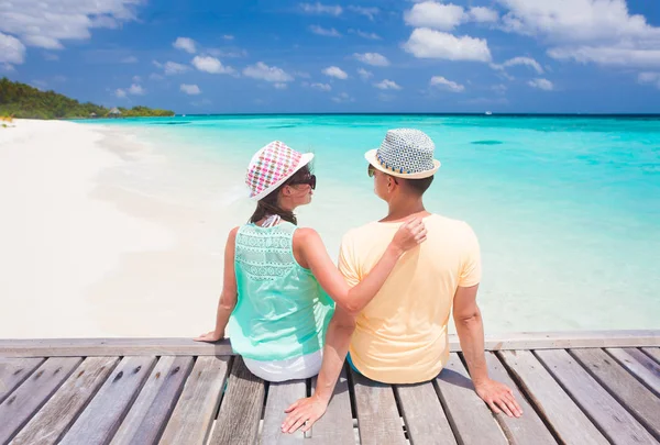 Vista trasera de la pareja sentada en una playa tropical en Maldivas — Foto de Stock