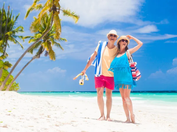 一对快乐的年轻夫妇，带着海滩饰物在海滩边玩乐 — 图库照片