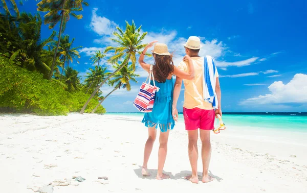 Happy young couple with beach accessories having fun by the beach — Stock Photo, Image