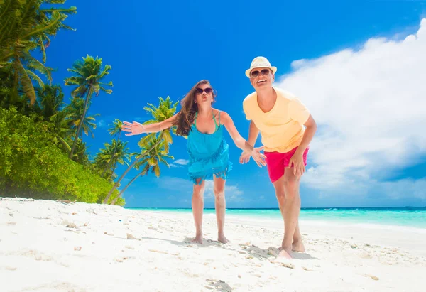 一对快乐的年轻夫妇，带着海滩饰物在海滩边玩乐 — 图库照片
