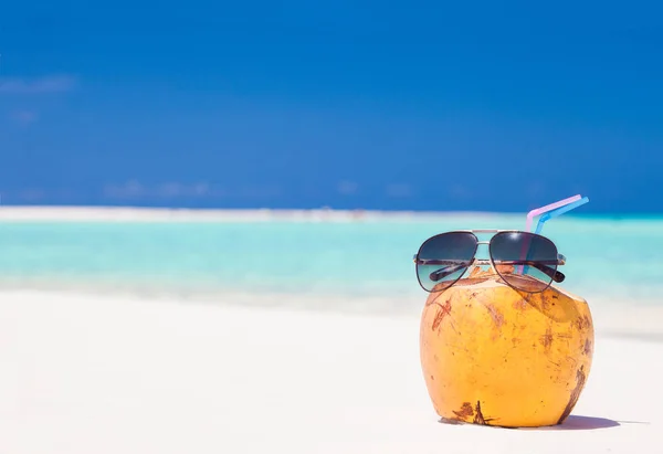 Foto van verse kokosnoot sap en zonnebril op tropisch strand — Stockfoto