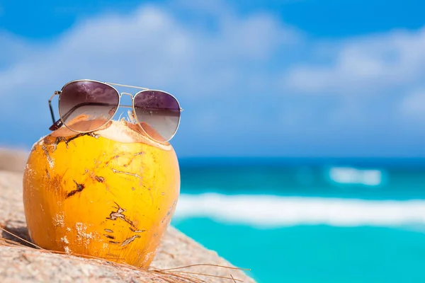 Cóctel de coco fresco y gafas de sol en una playa tropical — Foto de Stock