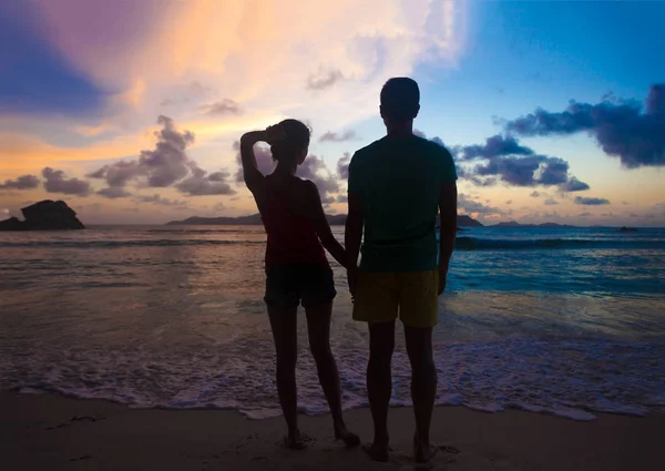 Solnedgång silhuett av unga par i kärlek kramas på stranden — Stockfoto