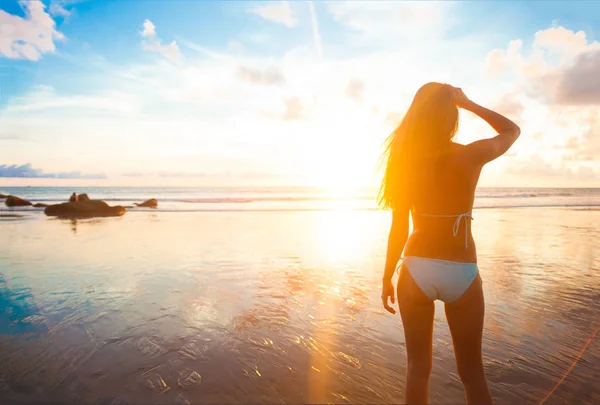 ビーチで夕日で走っている屈託のない女性。休暇活力健康的な生活のコンセプトです。水滴 — ストック写真