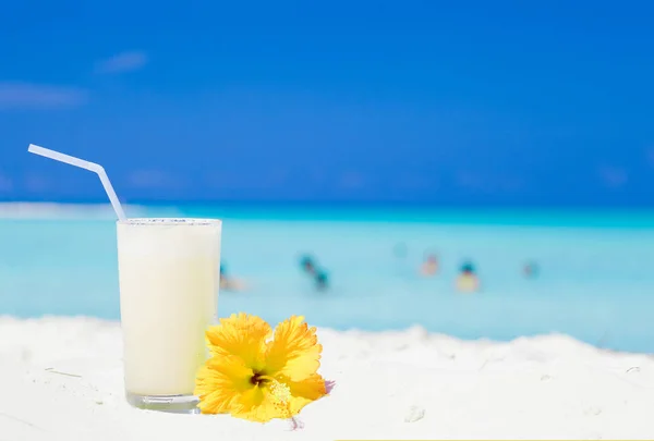 Glas Pina Colada Cocktail und gelber Hibiskus am Strand — Stockfoto