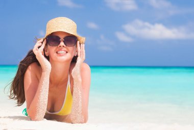 uzun saçlı genç kız bikini ve tropikal kumsalda gülümseyen güneş gözlüğü