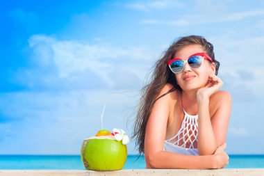 güneşli bir gün tropikal plaj keyfi, beyaz bikini ve wirh Hindistan cevizi genç uzun saçlı kız