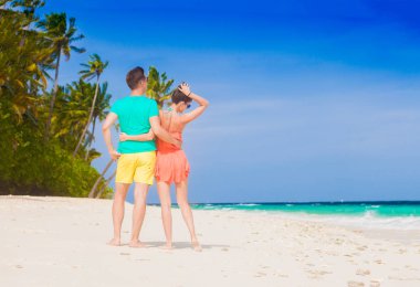 Genç mutlu aile tropik sahilde eğleniyor.