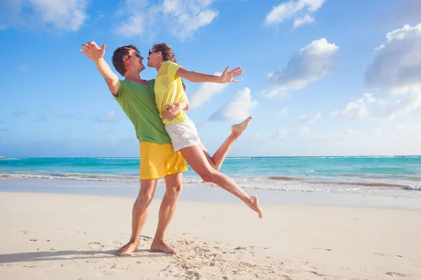 Imagen de pareja feliz en gafas de sol divirtiéndose en la playa — Foto de Stock