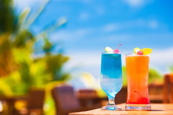 Dos deliciosos cócteles de frutas en la mesa junto a la playa — Foto de Stock