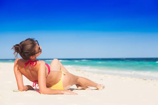 Vrouw in bikini en stro hoed liggend op tropisch strand — Stockfoto