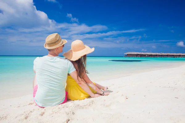 Vista trasera de la pareja sentada en una playa tropical en Maldivas Imagen de archivo