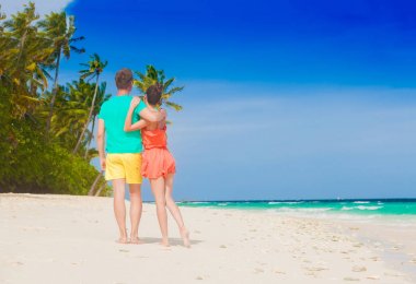 Genç mutlu aile tropik sahilde eğleniyor.