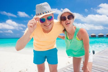 Genç mutlu aile tropik sahilde eğleniyor.