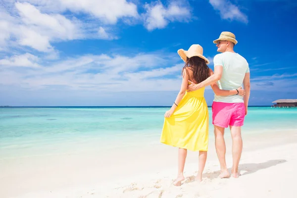 Feliz joven pareja caminando y divirtiéndose por la playa — Foto de Stock