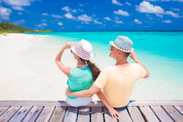 Vista trasera de la pareja sentada en una playa tropical en Maldivas Fotos de stock