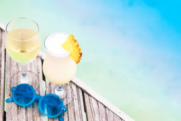 Delizioso cocktail di frutta e vino bianco con occhiali da sole sul tavolo in legno vicino alla spiaggia — Foto Stock