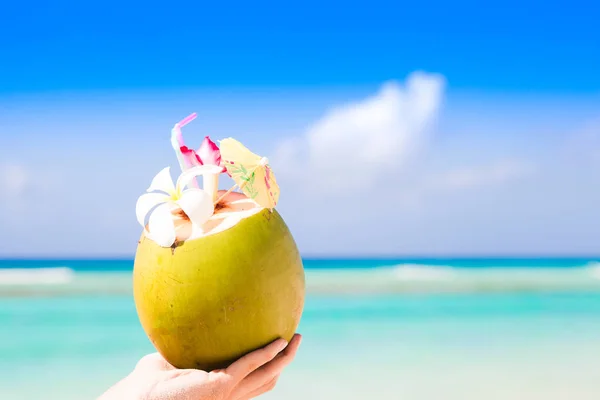 Köstlicher frischer Kokoscocktail mit Regenschirm in der Hand — Stockfoto