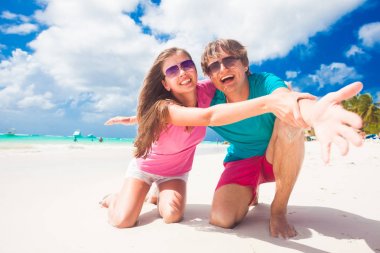 Kumsalda gülüyor parlak giysili genç mutlu çift closeup