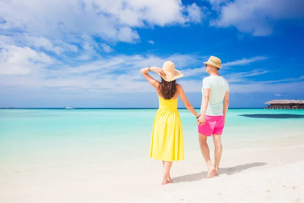 Счастливая молодая пара гуляет и веселится на пляже — стоковое фото