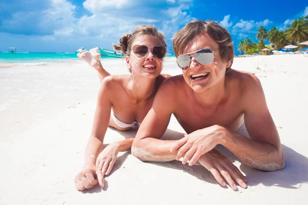 Portrét šťastný mladý pár s opalovací krém tečkami na pláži — Stock fotografie