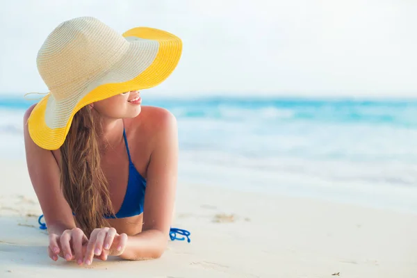 Ritratto di giovane donna dai capelli lunghi in cappello da sole rilassante in spiaggia la sera — Foto Stock