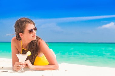 uzun saçlı kadın rahatlatıcı margherita kokteyl ile beyaz kum plaj, Bikini