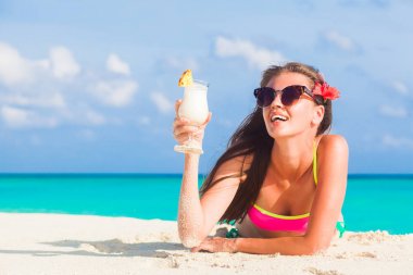 uzun saçlı kadın rahatlatıcı pina colada kokteyli ile beyaz kum plaj, Bikini