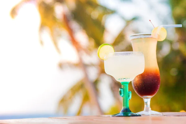 Glass of fruit cocktail and sunglasses by the beach — Stock Photo, Image