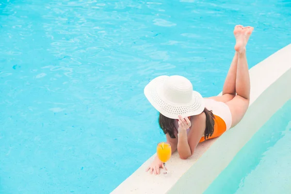 Meisje in stro hoed met drinken smoothie in het zwembad — Stockfoto