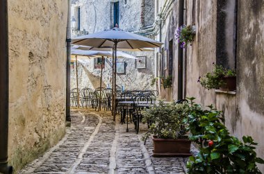 Typical street in the city of erice with its restaurant clipart