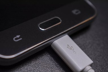 Beyaz kablo siyah zemin üzerine siyah smartphone