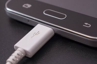 Beyaz kablo siyah zemin üzerine siyah smartphone