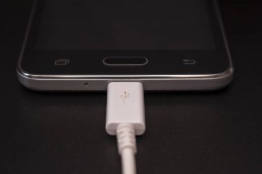 Beyaz kablo siyah zemin üzerine siyah smartphone