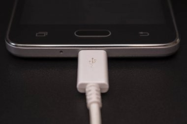 Beyaz kablo siyah zemin üzerine siyah smartphone