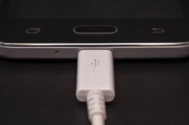 Beyaz kablo siyah zemin üzerine siyah smartphone